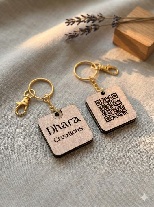 Custom wood keychain with Dhara Creations engraved on front and QR code on back