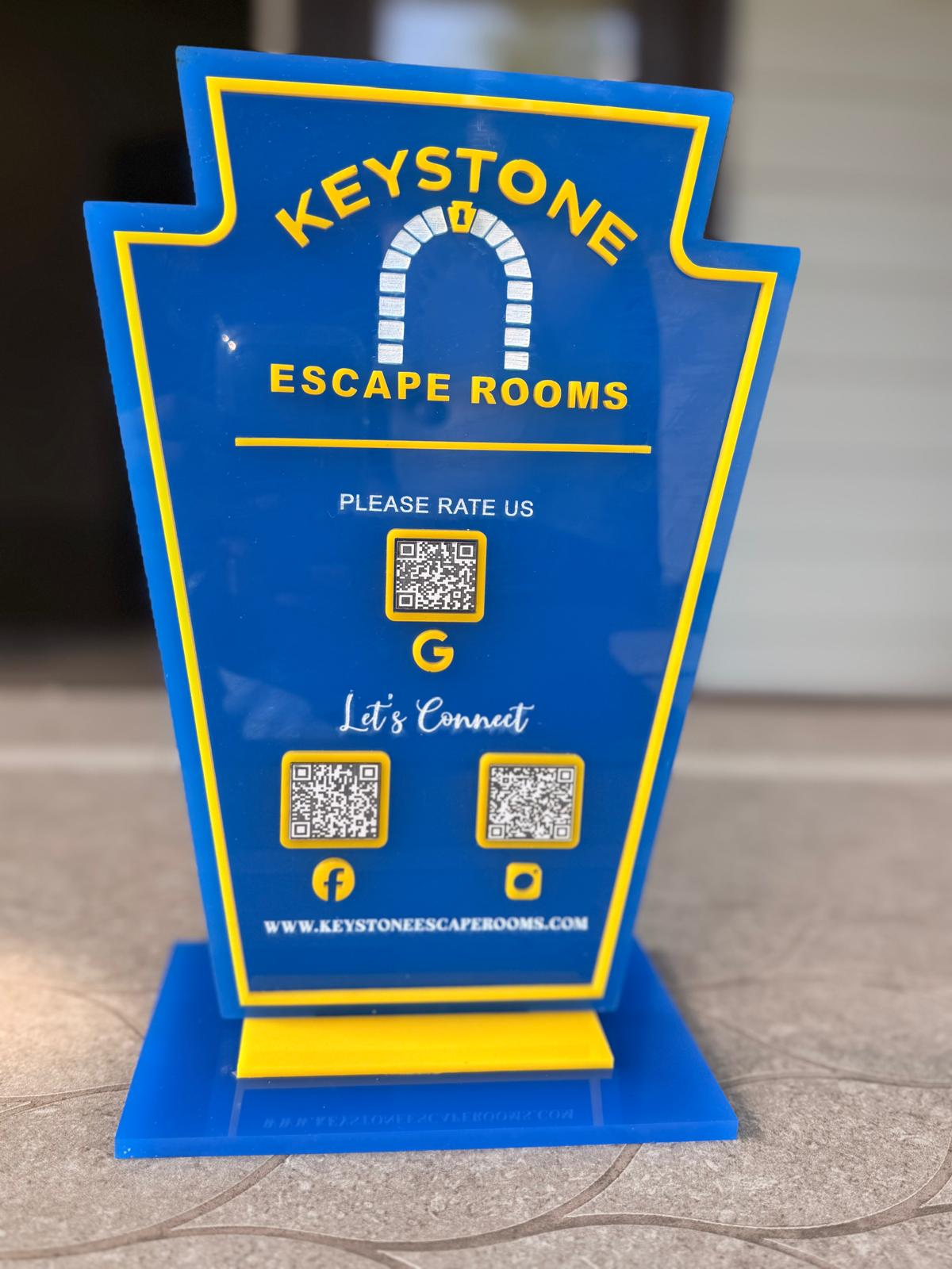 Custom acrylic QR sign stand in blue and yellow for Keystone Escape Rooms