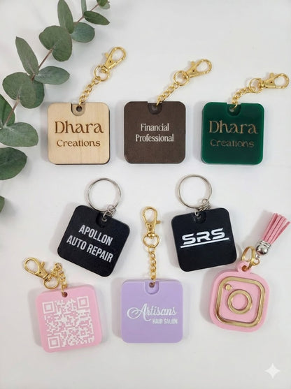 Collection of custom acrylic and wood keychains with business names and QR codes